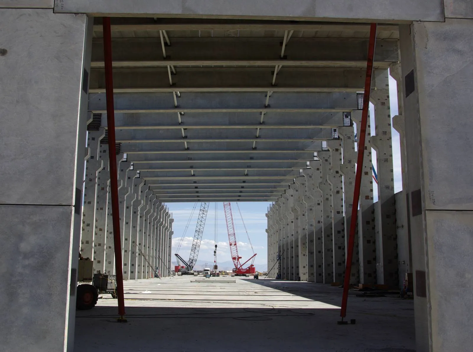 View down the ATI interior bay framed by precast columns and roof beams, cranes beyond